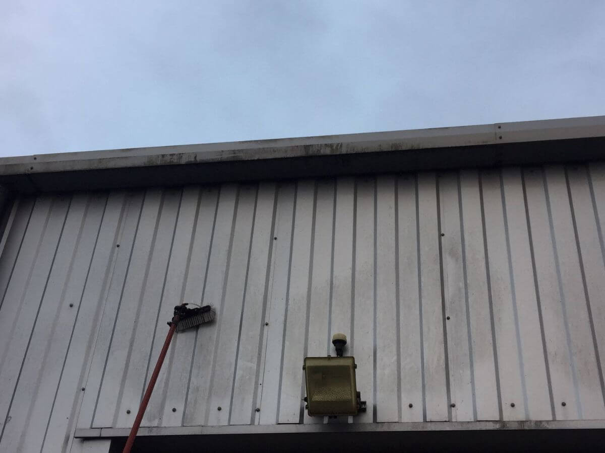Commercial cladding cleaning on an industrial building using a water-fed pole system in Suffolk.