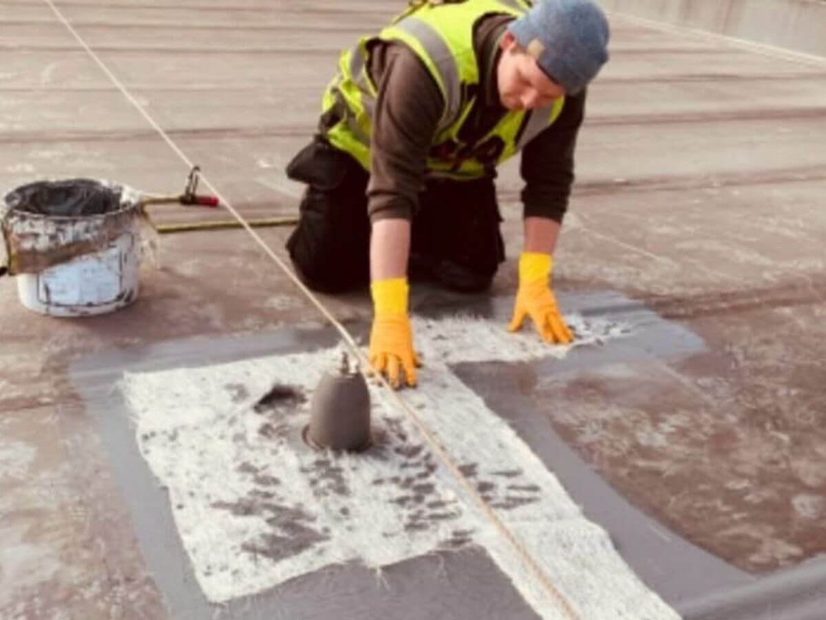Commercial roof repair being completed on a flat roof by TLC Window Cleaning technician in Suffolk.