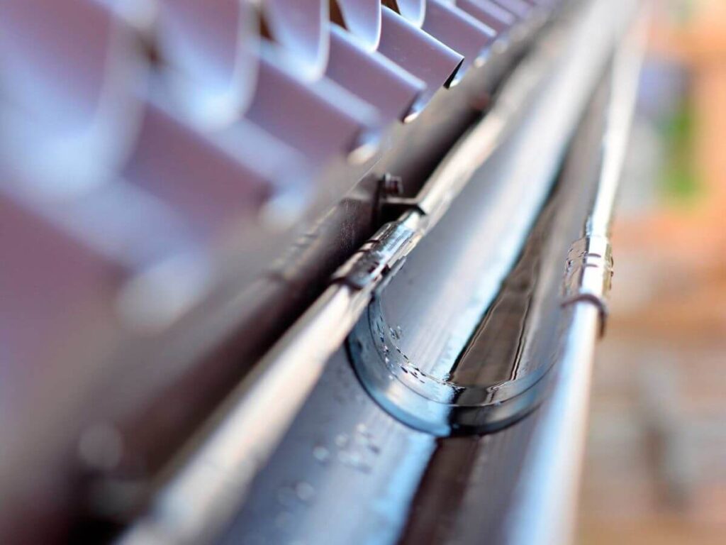 Gutter system cleared of leaves, moss and debris to restore proper water flow and performance