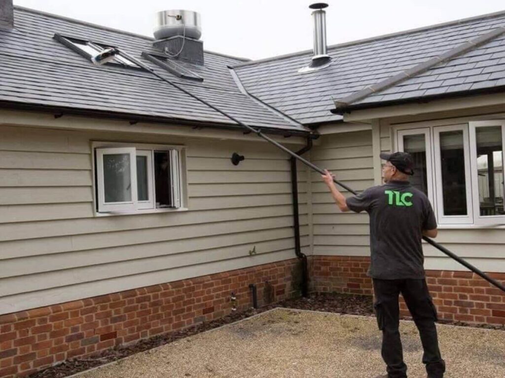 Window cleaner carrying out residential window cleaning using a water fed pole system.
