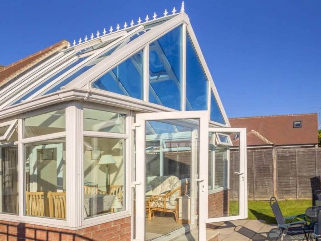 Clean white conservatory exterior with sparkling glass and frames after professional cleaning