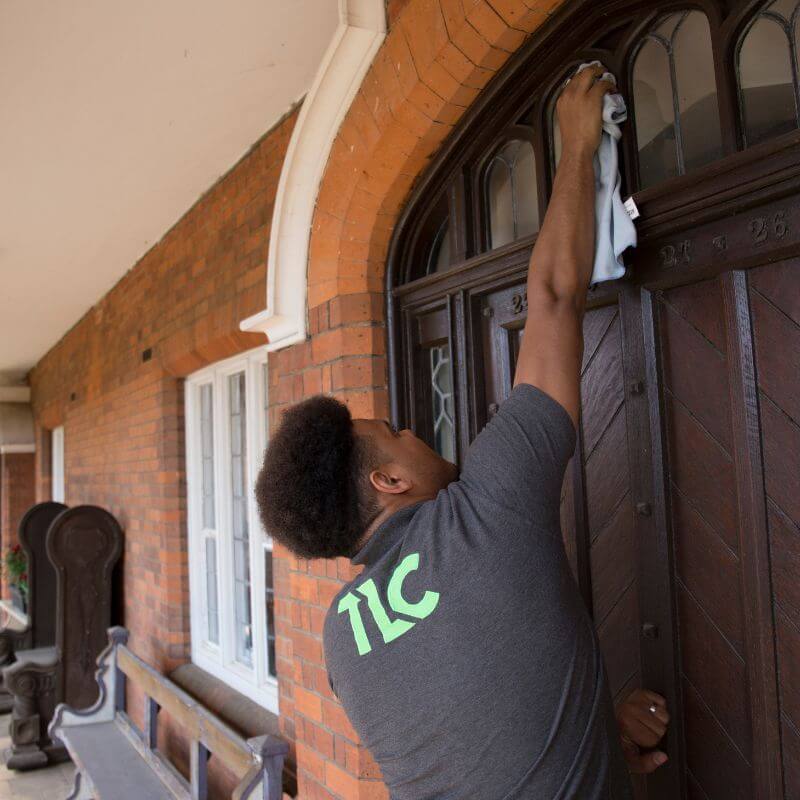 TLC technician providing window cleaning Ipswich services, thoroughly cleaning window frames and sills.